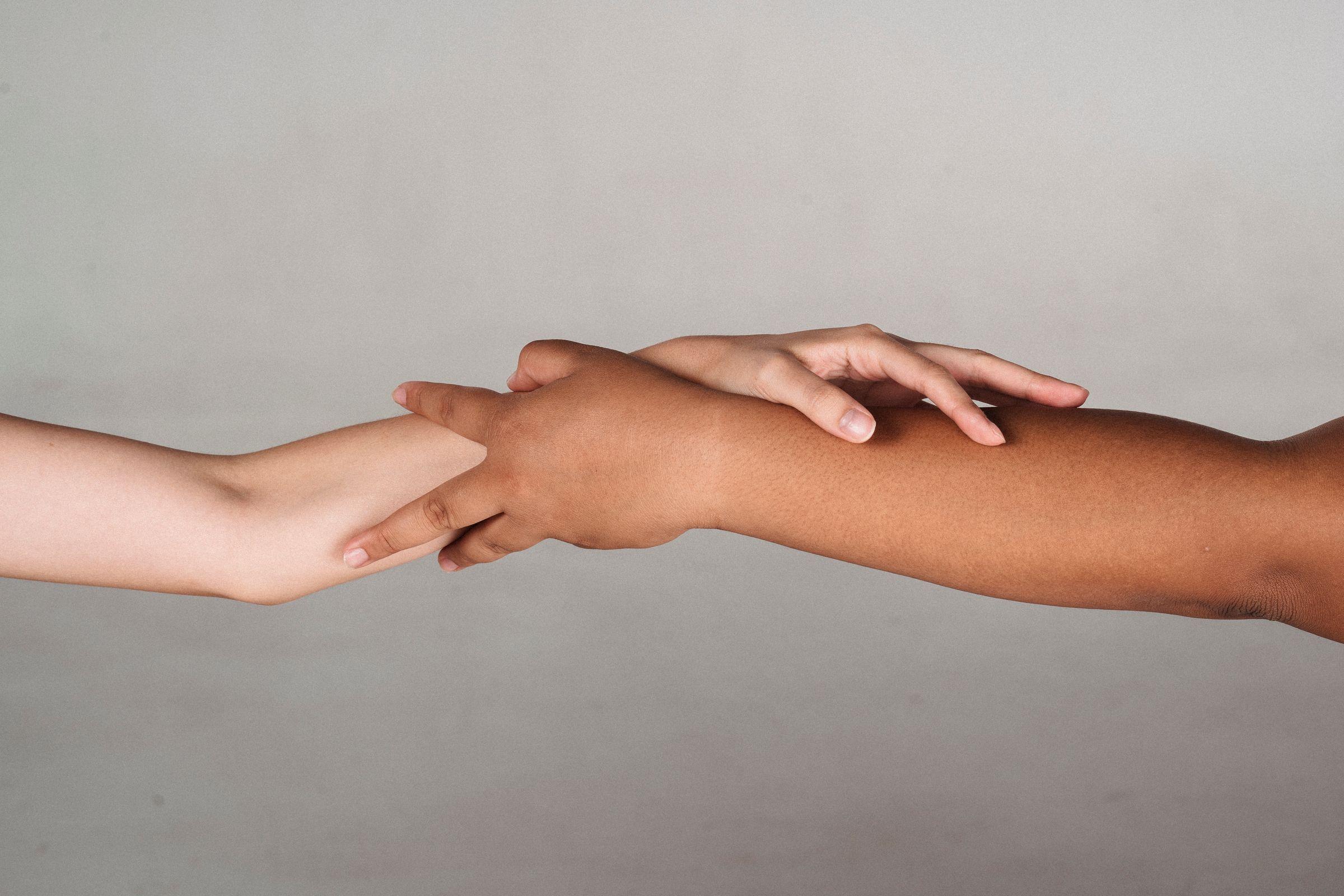Two people holding hands in solidarity.